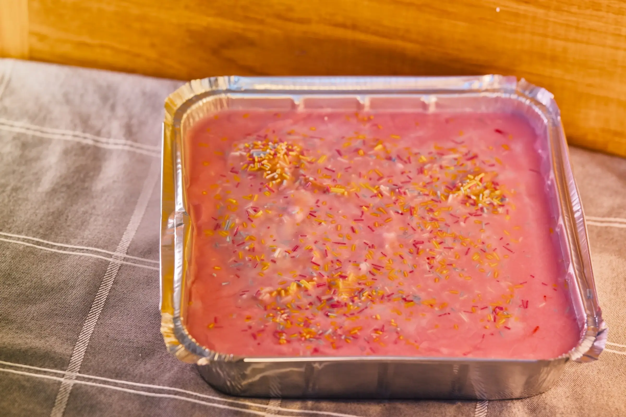 Vegan school cake squares with white icing and sprinkles.